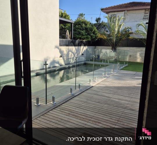 גדר זכוכית סביב בריכה בחצר בית